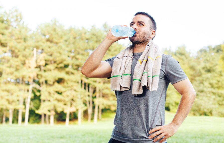 Young man drinking water after workout